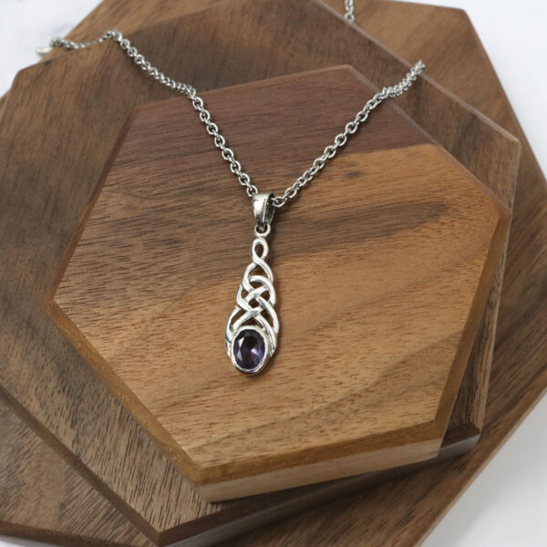 An Amethyst Celtic Knot Necklace adorned with a stunning amethyst pendant made of sterling silver.