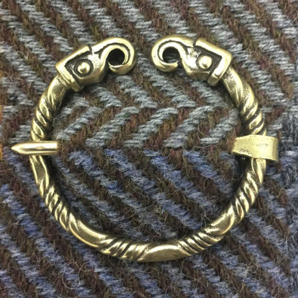 A brass bracelet with two hooks on it.