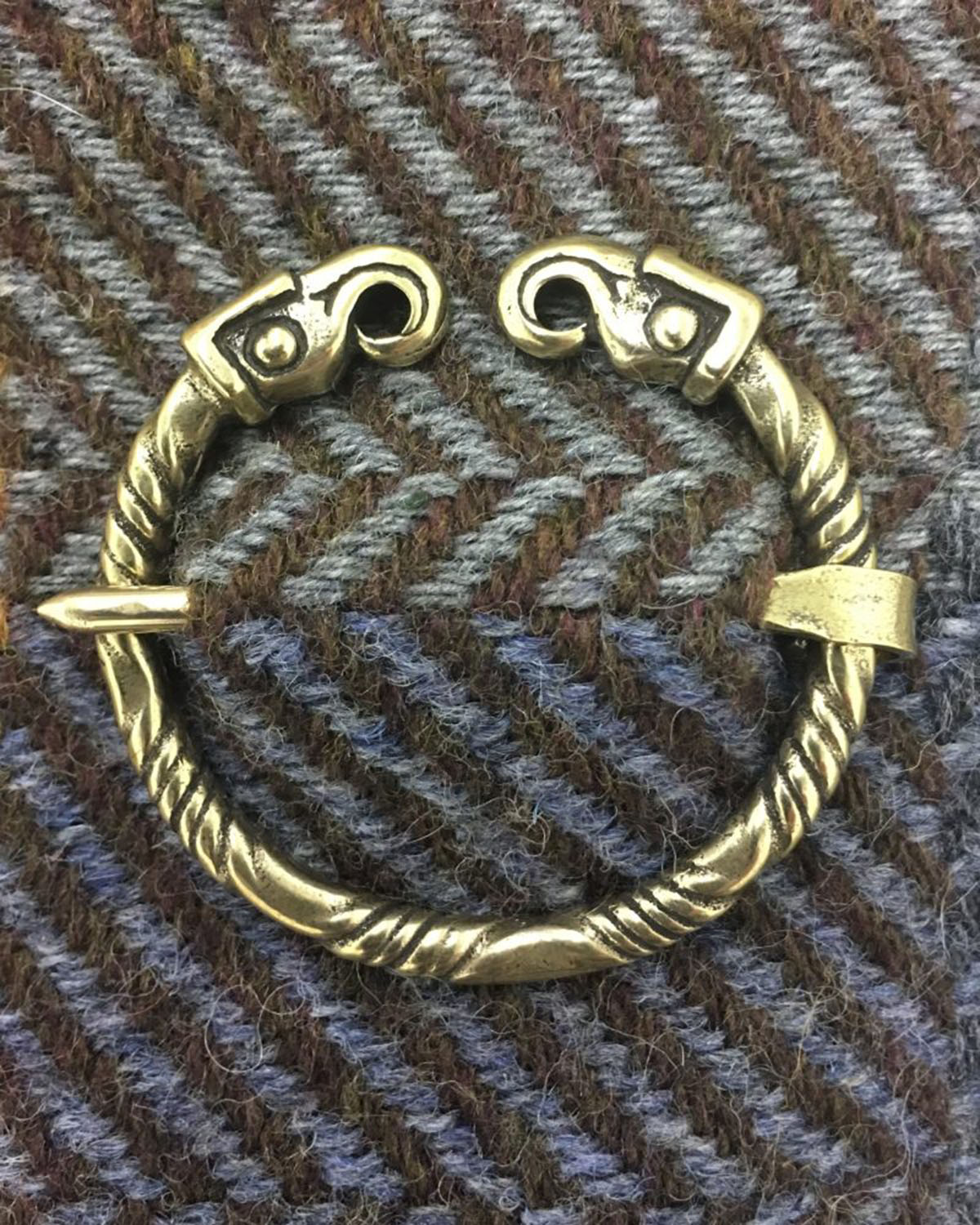 A brass bracelet with two hooks on it.