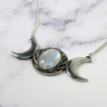 An Amethyst Celtic Knot Necklace with three moon phases, incorporating amethyst gemstones.