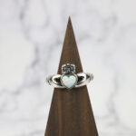 A Two Tone Eternity Knot Band claddagh ring with an opal heart.