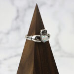 A Two Tone Eternity Knot Band with a woven band and opal heart.