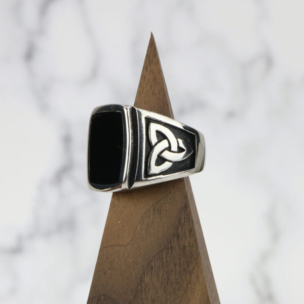 A sterling silver ring with a Black Onyx Stainless Steel Triquetra Ring in the middle.