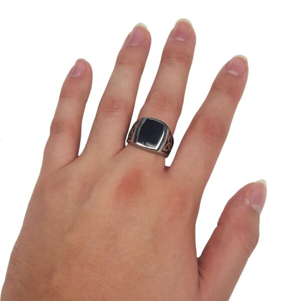 A hand with a Black Onyx Stainless Steel Triquetra Ring.