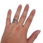 A Tree of Life Sterling Silver Ring adorned with the symbol of the tree of life gracefully rests on a hand.