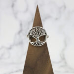 A Two Tone Eternity Knot Band ring on a wooden base.