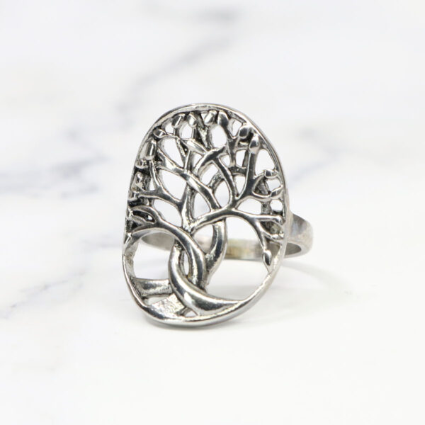 A Tree of Life Stainless Steel Ring on a marble table.