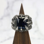 A Dragon Claw Stainless Steel Ring with a blue sapphire on top.