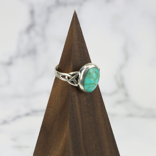 A Turquoise Triquetra Ring with a turquoise stone on top.