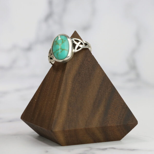 A Turquoise Triquetra Ring featuring a triquetra design made from wood.