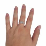 A woman's hand with an Infinity Knot Ring on it.