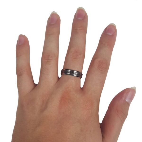 A woman's hand elegantly showcasing a stainless steel Celtic Knot Spinner Ring.
