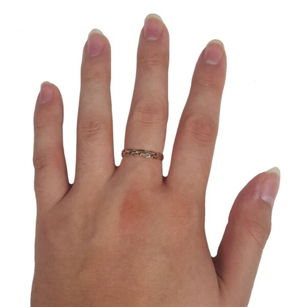 A woman's hand adorned with a beautifully crafted Two Tone Eternity Knot Band gold ring.