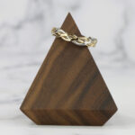 A wooden triangle with a Two Tone Eternity Knot Band.