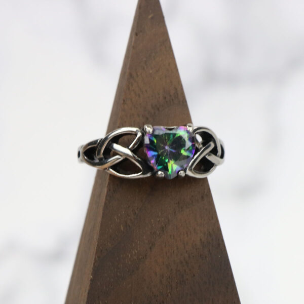A Mystic Crystal Celtic Knot Heart Ring with an amethyst in the center.