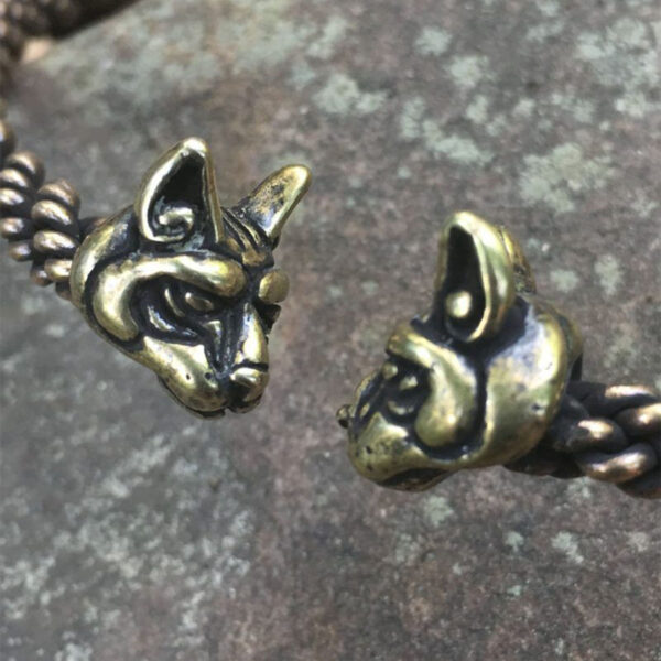 A pair of Cat Torc - Light Braid cuff bracelets with a cat head on them.