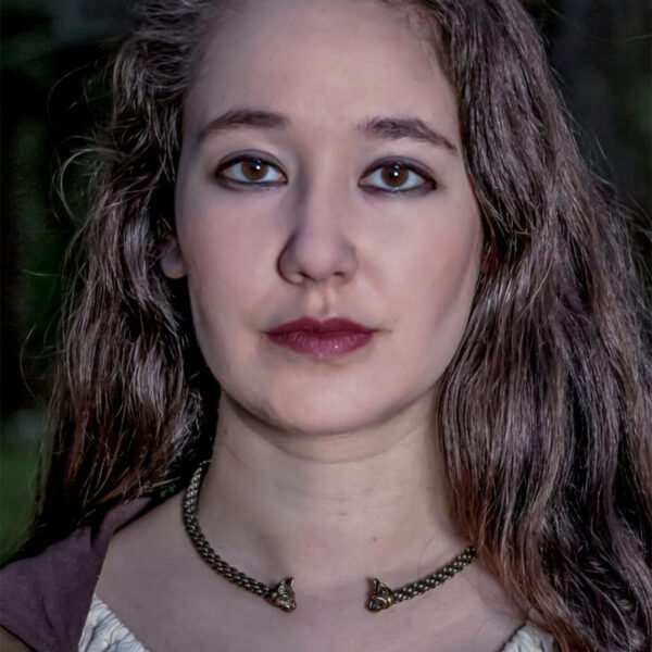 A young woman wearing a Cat Torc - Light Braid necklace in the woods.
