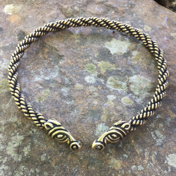 A bracelet with two Celtic Horse Neck Torcs on top of a rock, inspired by horse torcs.
