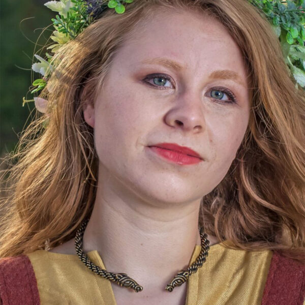 A young woman wearing a crown of flowers and a Celtic Horse Neck Torc.