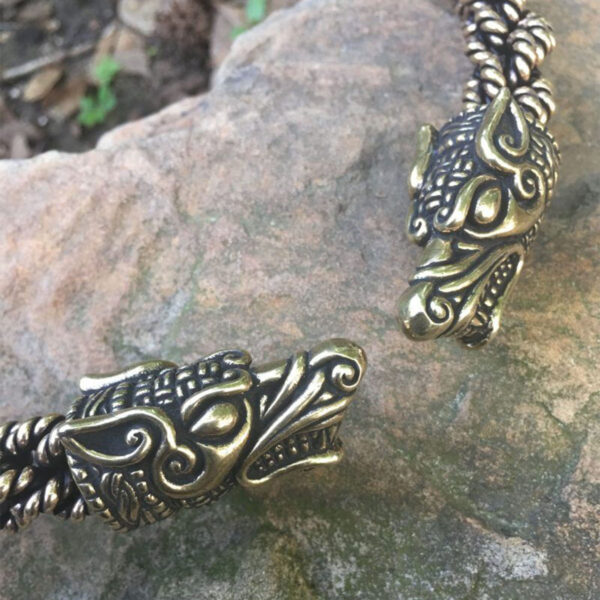 Two Norse Wolf Torc Extra Heavy Braid bracelets resting on a rock.