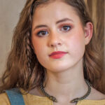A young woman wearing a Celtic Raven Neck Torc, adorned with a snake on it.
