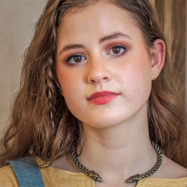 A young woman wearing a Celtic Raven Neck Torc, adorned with a snake on it.