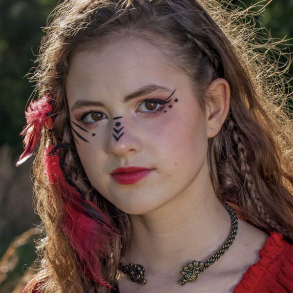 A girl in a red dress wearing a Celtic Stag Neck Torc with feathers on her face.