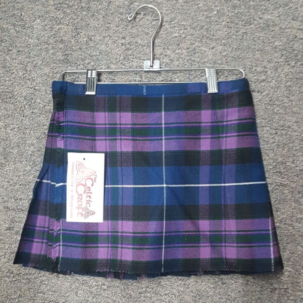 A blue and purple Pride of Scotland Homespun Child's Kilt 24W 12L hanging on a hanger.
