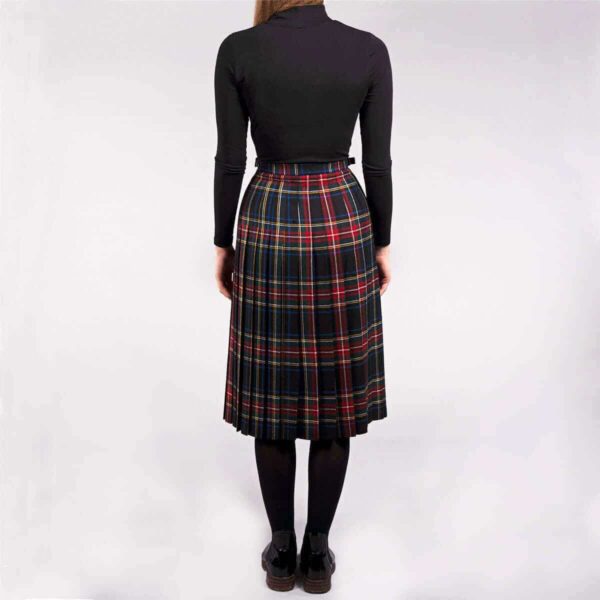 The back view of a woman wearing a plaid skirt.