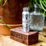 A bottle of beeswax is sitting on top of a wooden box containing the Nutdust Sampler Pack of 3.