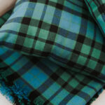 A Homespun Tartan Blanket/Throw on a bed.