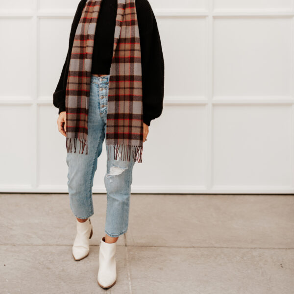 A woman wearing a Tartan Scarf - OUTLANDER Lambswool and white jeans.