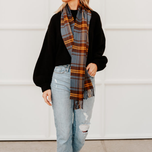 A woman wearing ripped jeans and a Tartan Scarf - Irish County Lambswool.