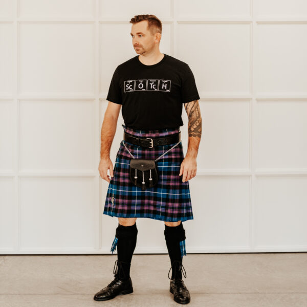 A man in a Quality Wool Blend Kilt with Matching Tartan Flashes and FREE Kilt Hanger standing in front of a white wall.