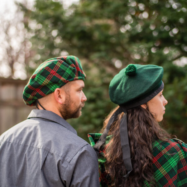 A man and woman dressed in kilts and hats.