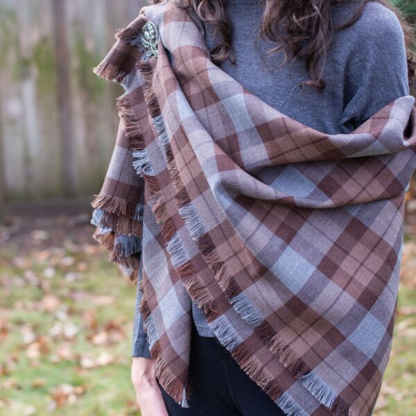 A woman wearing an OUTLANDER Shawl Authentic Premium Wool Tartan.