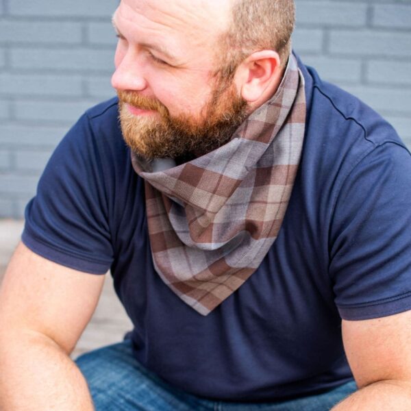 A bearded man wearing a plaid bandana.