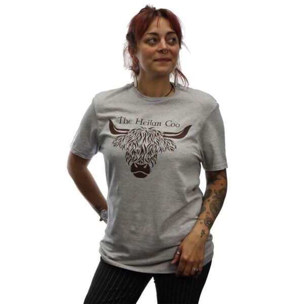 A woman wearing a grey t-shirt with a highland cow on it featuring the Dire Wolf T-Shirt.