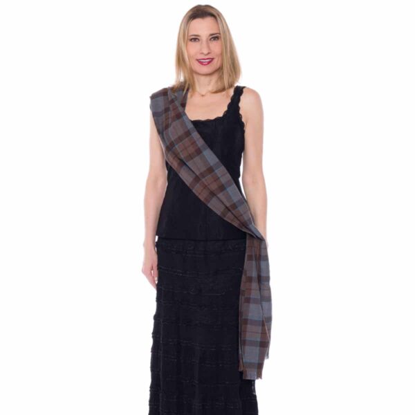A woman in a black dress with a plaid scarf.
