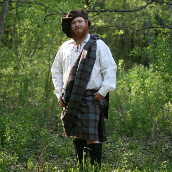 An OUTLANDER Ancient Kilt Authentic Premium Wool Tartan man standing among the woods.