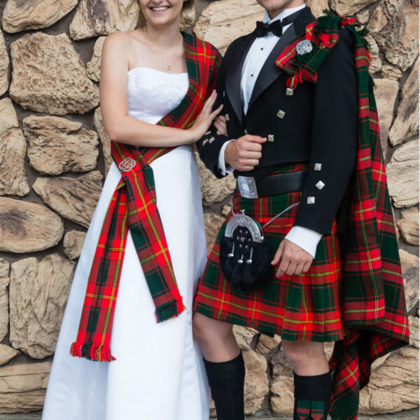 A man in a Prince Charlie Formal PLATINUM Package kilt and a woman in a dress.