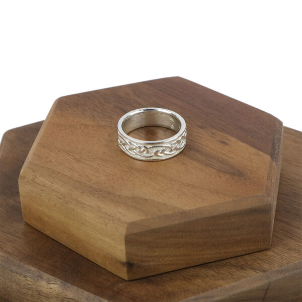 A Womens Sterling Silver Celtic Knot Wedding Band - Size 8* sits on top of a wooden box.