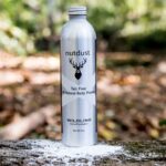 A bottle of Nutdust-Wildling sitting on a tree stump, surrounded by Wildlings.