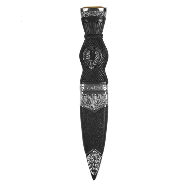 A MacArthur Pewter Thistle Clan Crest Sgian Dubh with a yellow gem on it.
