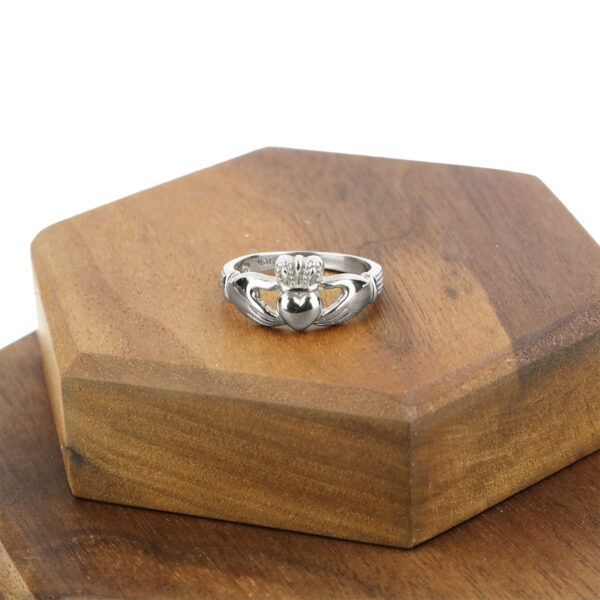 A Women's Sterling Silver Claddagh Wedding Ring placed on top of a wooden box.
