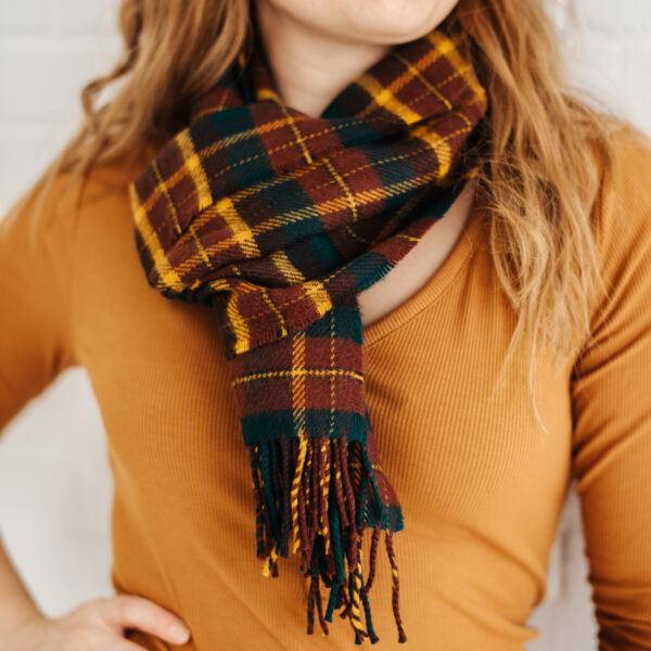A woman wearing a plaid scarf with tassels.
