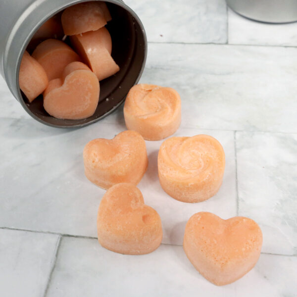 Heart shaped Homemade Candles in a tin on a marble counter.