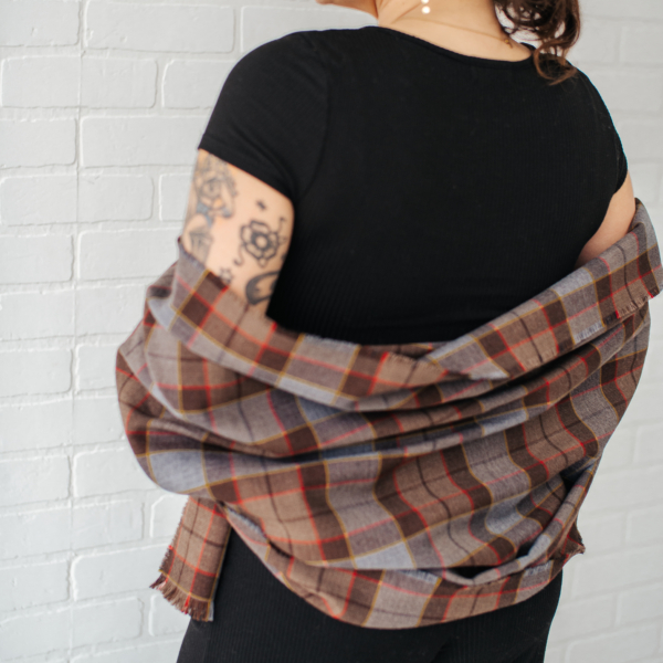 A woman with tattoos wearing an OUTLANDER Stole Authentic Premium Wool Tartan.