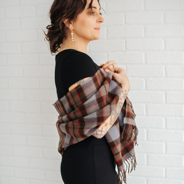 A woman wearing an OUTLANDER Stole Authentic Premium Wool Tartan.