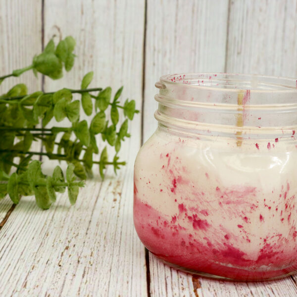 A homemade glass jar with Homemade Candles in it.